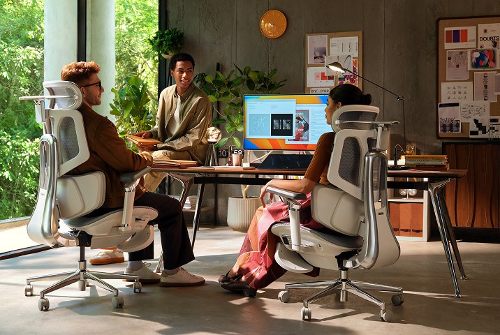 team menbers stting in hbada office chair by desk discuss