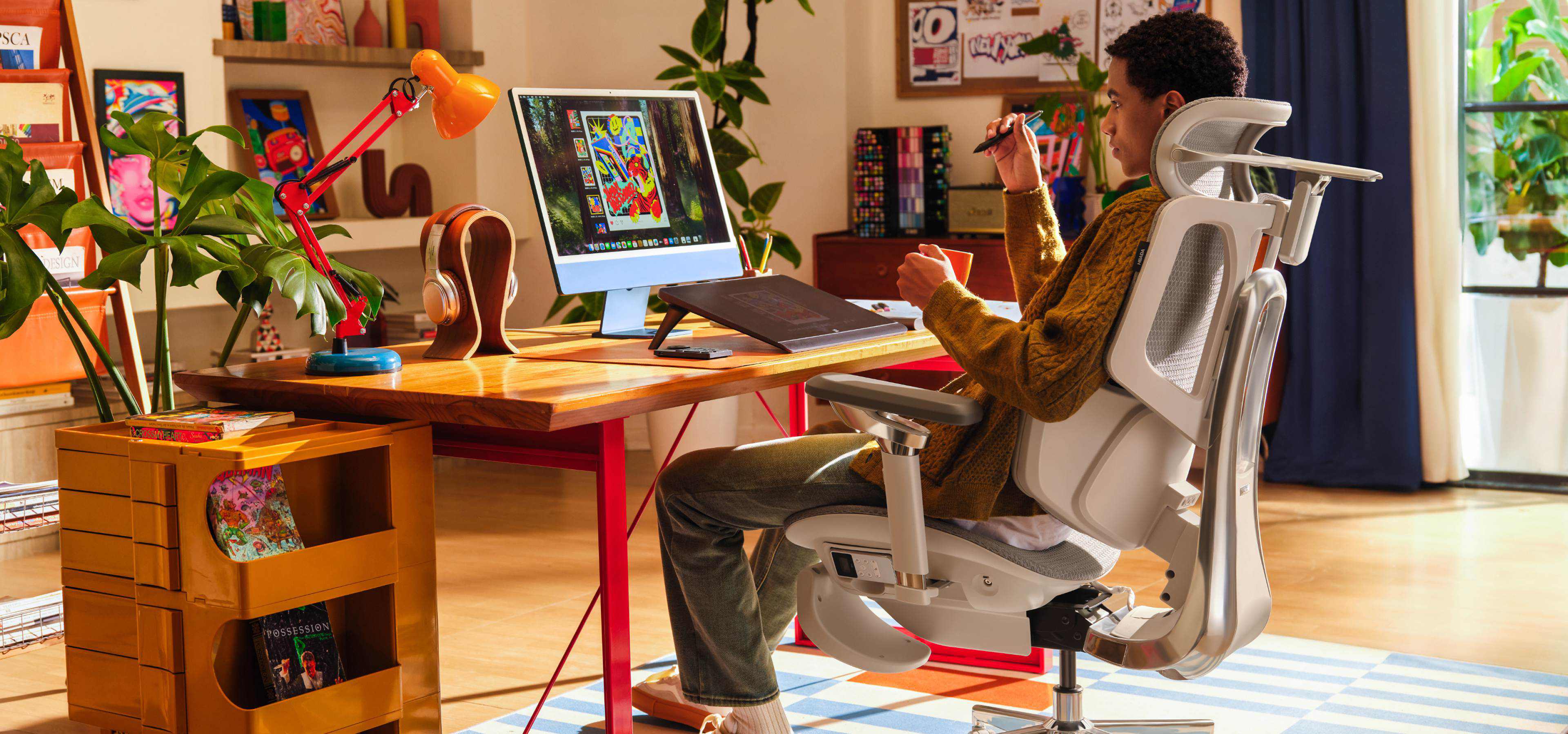 artist stting in HBADA ERGONOMIC CHAIR thinking